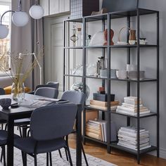 an image of a dining room table and chairs with bookshelves in the background