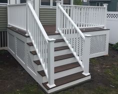 a set of stairs leading up to a house with white railings and wood handrails