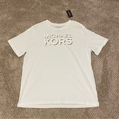 This Michael Kors T-Shirt For Men In Size Xl Is A Brand New Item With Tags Attached. The Shirt Has A Classic Crew Neck And Short Sleeves, And Comes In A Crisp White Color. It Is A Regular Fit And Made Of High-Quality Materials To Ensure Comfort And Durability. This T-Shirt Is Perfect For Any Casual Occasion And Can Be Paired With A Variety Of Outfits. Michael Kors Cotton Short Sleeve Tops, Casual Michael Kors Short Sleeve Tops, Casual Short Sleeve Michael Kors Tops, Casual Short Sleeve Tops By Michael Kors, Michael Kors Cotton Crew Neck Top, Michael Kors Cotton Top With Logo Print, Michael Kors Casual Short Sleeve T-shirt, Michael Kors Cotton Top With Graphic Print, Casual Michael Kors Short Sleeve T-shirt