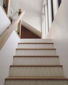 the stairs are made of wood and have glass railings