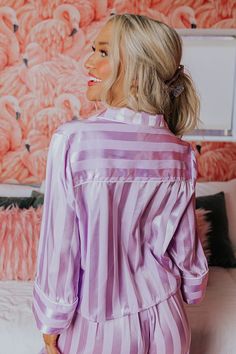 - Make time to unwind with luxe style in this cozy pajama top! - Lightweight, unlined material with a vertically striped pattern and a satin finish - A collared neckline - A functional chest pocket - Long, loose sleeves with cuffs - A button up front - A relaxed silhouette that ends in a straight hemline with accent side slits Luxe Style, Cozy Pajamas, Loose Sleeves, Pajama Top, Pj Sets, Make Time, Satin Finish, Chest Pocket, Lavender