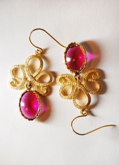 This listing is for a pair of filigree earrings. They feature matte gold filigree pendants with a fabulous texture, from which I've hung vintage gold-framed magenta glass. The glass pendants have a little weathering on them from age, but are in beautiful condition and catch the light really well. The total length of the earrings is just under an inch and a half.  *Photography by Allison Wolpert for AWOLArt Party Brass Filigree Earrings, Pink Earrings With Intricate Design For Gift, Yellow Gold Filigree Earrings For Party, Party Yellow Gold Filigree Earrings, Gold Filigree Earrings For Party, Filigree Pendant, Filigree Earrings, Gold Filigree, Glass Earrings