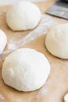 four uncooked doughnuts sitting on top of a table