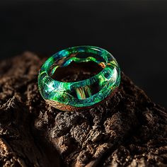 "Wood Resin Ring Made of Epoxy Resin and Exotic Wood. Green Resin Jewelry with Magic. Makes a Great Gift. Present this unusual ring! I hand select only the highest quality of wood from noble tree species that encase a piece of nature, spirit and energy from the place where it was growing. I finish the wood with natural and eco-friendly carnauba wax and flaxseed oil to give a wonderful matte lustre as well as make it weatherproof. The resin has a high clarity, hardness and optimal light refractio Luminous Jewelry For Gift, Luminous Ring Jewelry For Gifts, Luminous Ring Jewelry As A Gift, Mystical Green Rings Perfect For Gifts, Green Luminous Round Jewelry, Unique Green Resin Ring, Unique Green Resin Rings, Mystical Green Jewelry For Gift, Mystical Green Jewelry As Gift