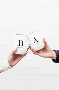 two people holding open books with letters on them