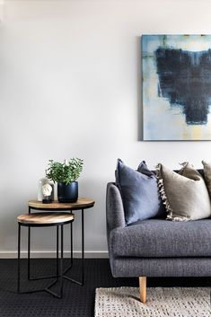 a living room filled with furniture and a painting on the wall