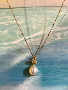 This exquisite necklace features a lustrous baroque freshwater pearl, cultivated for its unique irregular shape and captivating texture, ensuring that each piece is truly one-of-a-kind. Sitting atop the pearl is a floral adornment crafted from S925 silver, embellished with sparkling zirconia stones that add a touch of glamour. The pendant is suspended on a durable stainless steel chain, which complements the pendant's sheen and offers lasting shine. The design embodies a luxurious yet refined aesthetic, perfect for elevating any formal ensemble. Luxury Drop Pearl Pendant Necklace, Luxury Pear-shaped Pearl Chain Necklace, Elegant Baroque Pearl Round Pendant Necklace, Elegant Teardrop Pearl Chain Necklace, Elegant Baroque Pearl Jewelry In Pear Shape, Formal Baroque Pearl Pendant Necklace, Elegant Briolette Necklace With Pearl Charm, Elegant Gold Briolette Pearl Necklace, Pearl Necklace With Flower Pendant And Pearl Charm