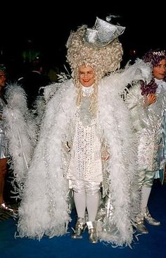 the woman is dressed in white feathers and posing for a photo with two other people