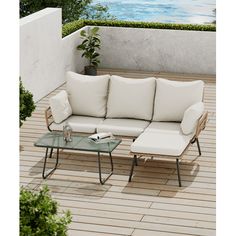 a white couch sitting on top of a wooden floor next to a table and chair