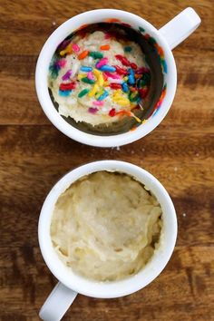 two mugs filled with ice cream and sprinkles on top of a wooden table