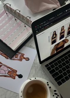 an open laptop computer sitting on top of a desk next to a cup of coffee