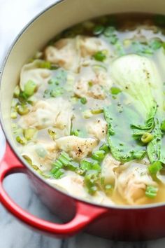 a red pot filled with soup and broccoli