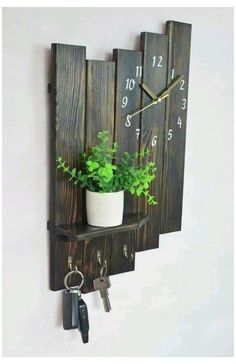 a wooden wall clock with plants and keys on it