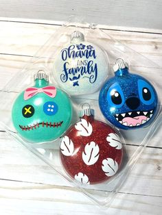 three christmas ornaments in the shape of jack and sally ornament, one with an evil face