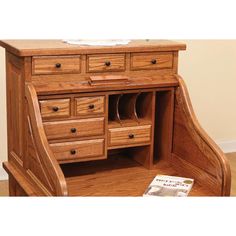 a wooden desk with several drawers and a magazine holder on the bottom shelf next to it