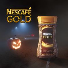 a bottle of nest safe gold next to a jack - o'- lantern