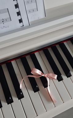 a pink ribbon tied to the keys of a piano