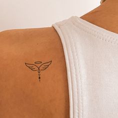 a person with a small tattoo on their back and shoulder is looking at the camera