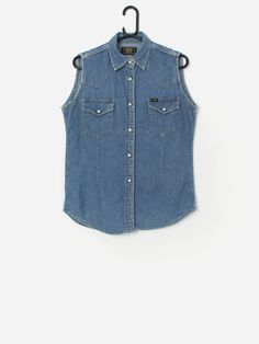 Vintage Lee Union Made sleeveless denim shirt. This 80s/90s fitted denim shirt vest features two chest pockets with snap button closures, a snap button closure and is made from a lightweight soft cotton.  Our recommended size: Medium Label says: Medium Condition: Very good  Material: 100% cotton Measurements in inches: Pit to pit: 19.5 Shoulders: 14 Front length: 26.5 Back length: 27 We recommend that you compare our measurements to a similar item of your own to ensure good fit. Measurements are Fitted Denim Shirt, Union Made, Vest Shirt, Womens Vest, Denim Shirt, Textiles