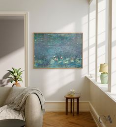 a painting hanging on the wall above a couch in a room with wooden flooring