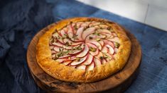 an apple pie is sitting on a wooden platter