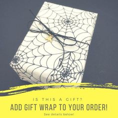 a gift wrapped in white paper with spider web on it and the words, is this a gift?