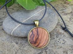 "Lovely bronze pendant medallion with a handmade cabochon Ø 25 mm - 0.98 inches in fine olive wood with a 75 cm - 29.5 inches long bronze plated chain or an adjustable leather cord 1 meter ( 39.37 \" ) naturally the grain of the olive wood can vary from item to item , but in any case you will get a pendant with an olive wood cabochon with beautiful grain handcrafted by us in Portugal the olive wood is finely sanded and oiled with olive oil" Round Necklace In Natural Color For Gift, Round Natural Color Necklace As Gift, Natural Round Necklace For Gift, Natural Color Necklace For Gift, Artisan Necklaces In Natural Wood As Gift, Artisan Necklace In Natural Wood As A Gift, Artisan Natural Wood Necklace As A Gift, Artisan Natural Wood Necklaces For Gift, Handmade Bohemian Round Disc Jewelry