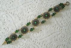 "This beautiful bracelet has seed beads, green Czech glass beads, antique gold accent beads and antique gold filigree settings accented with rhinestones. 7\" long. Toggle clasp." Antique Gold Beaded Jewelry With Round Beads, Elegant Antique Gold Bracelet Jewelry, Vintage Beaded Jewelry With Czech Glass, Victorian Metal Bracelet Jewelry, Elegant Brass Bracelets For Jewelry Making, Handmade Elegant Brass Bracelet, Elegant Bronze Bracelets With Round Beads, Elegant Brass Jewelry With Decorative Details, Victorian Metal Bracelet