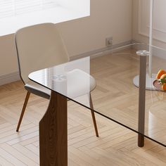 a glass dining table with two chairs and an orange on the floor next to it