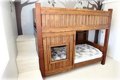 a wooden bunk bed sitting next to a stair case in a room with white walls