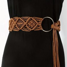 a woman wearing a brown belt with a ring on the bottom and tassels