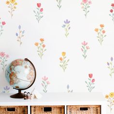 a wall with flowers painted on it next to baskets and a globe in the foreground