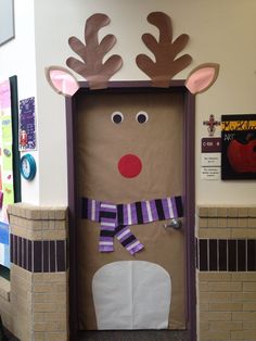 a cardboard door decorated to look like a reindeer with purple and white striped scarfs