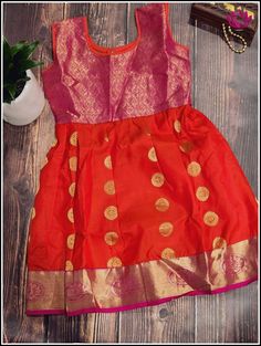 Silk cotton dress for kids in pink and orange with floral zari motifs. The pink border has beautiful peacock motifs in golden zari. Size - 3/4 yr old Please note: Color may vary slightly from the picture. Handwash/dry clean only Orange Chanderi Dress With Cutdana Details, Orange Anarkali Dress With Cutdana, Orange Cutdana Dress For Diwali, Pink Chanderi Dress With Dori Work, Festive Orange Chanderi Dress, Orange Cutdana Traditional Drape Dress, Festive Orange Dress With Cutdana Details, Orange Chanderi Dress With Traditional Drape, Orange Chanderi Bollywood Dress