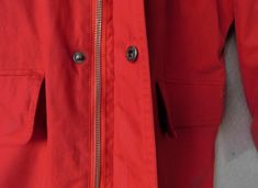 "Red raincoat with detachable hood, mock collar Zipper closure with snap buttons and draw string Two zip front pocket Two pockets with snap buttons;Two inside pockets with zipper Shell - 75% cotton, 25% polyamide; 100% polyamide lining - polyamide is water resistant fabric Was designed in France Signs of normal wear - a tiny pin-size discolored at front bottom. Hardly noticeable. Other than that, condition is great Dimension - shoulder 20\", armpit to armpit 24\", sleeve 25.5\", length 32\"" Red Hooded Raincoat For Winter, Red Hooded Raincoat For Fall, Red Winter Outerwear For Rainy Weather, Red Raincoat, Red Rain, Red Water, Knit Men, Saint James, St James