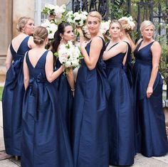 a group of women in blue dresses standing next to each other