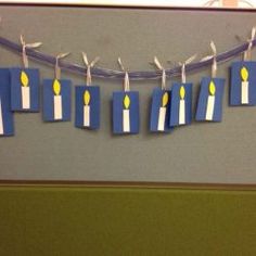 some paper candles are hanging on a string