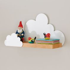 a shelf that has some books on it and a gnome figurine next to it