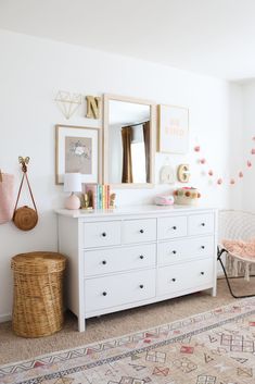 a white dresser sitting in a bedroom next to a mirror