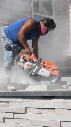 a man using a chainsaw to cut concrete