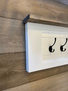 a close up of a sign on a wooden wall with ear buds attached to it