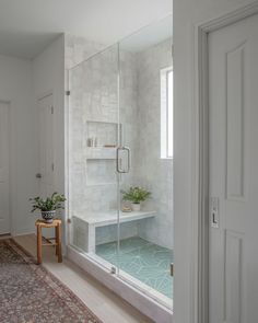 a bath room with a stand up shower and a rug