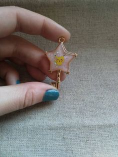 a woman's hand holding a star shaped brooch