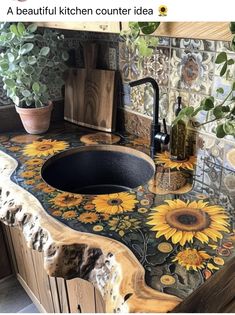 a kitchen counter with sunflowers painted on the top and bottom, along with potted plants