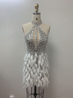 a mannequin with silver and white feathers on it