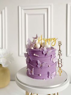 a purple birthday cake sitting on top of a table