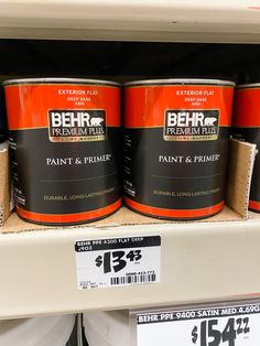 paint and primer are on display for sale in a store shelf with price tags