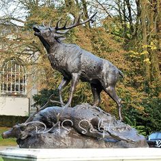 a statue of a stag standing on top of a rock