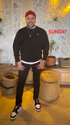 a man standing in front of a stone wall with the words sunday written on it