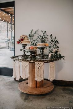 a table topped with cakes and cupcakes on top of a wooden stand